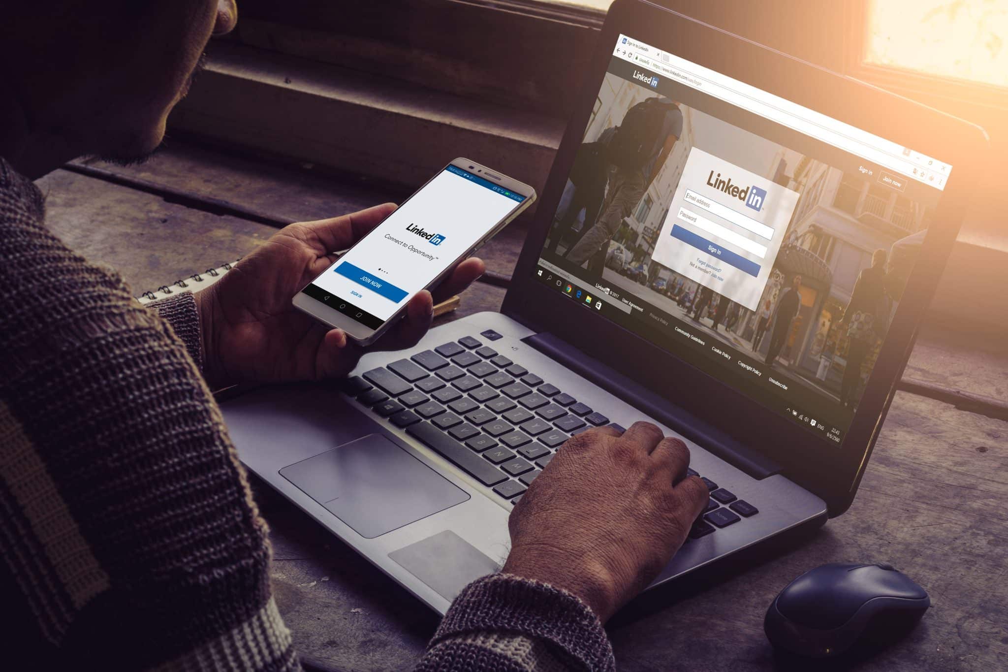 صورة لاستخدام منصّة لينكد إن (LinkedIn) على الكمبيوتر المحمول والهاتف الذكي