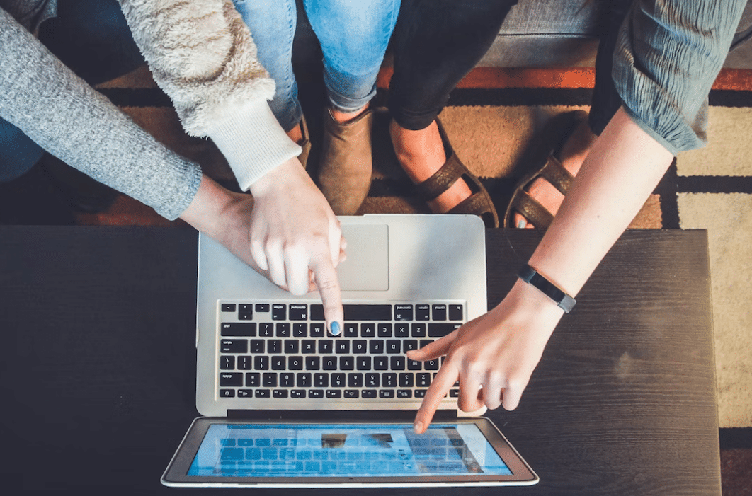 3 personer peker på laptop skjerm