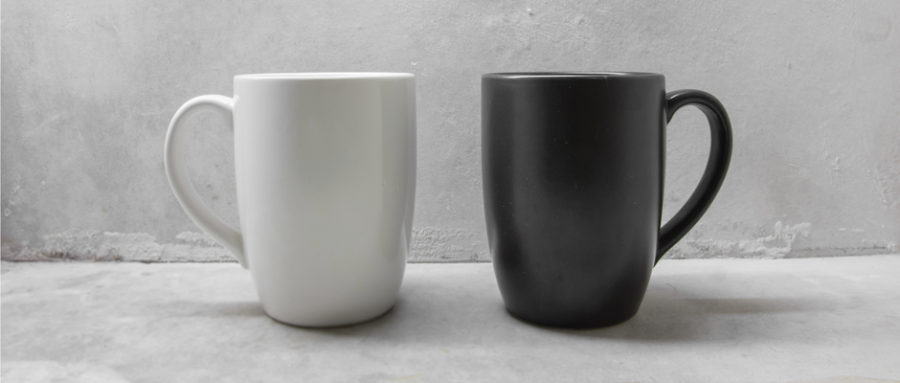 a white mug next to a black mug