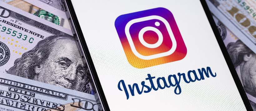 How to monetize Instagram: Instagram logo mobile app on screen smartphone iPhone with dollars, money closeup