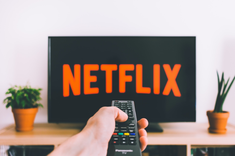 netflix on a TV with someone holding a remote