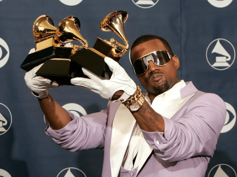 Kanye West holding 3 Grammy awards