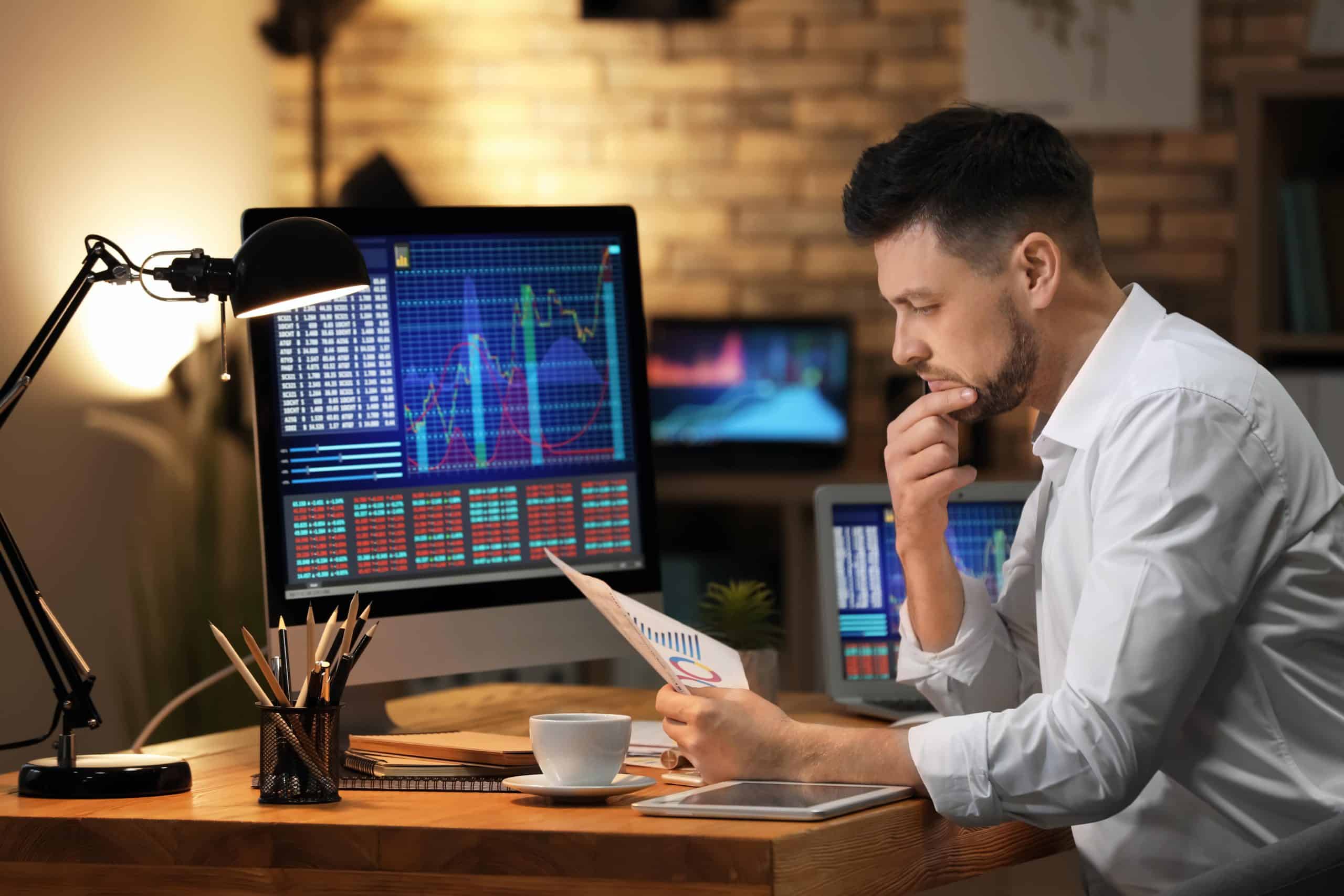 man looking at paper at desk