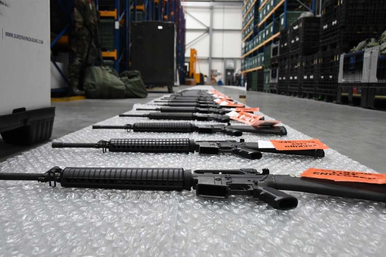 rifles laying on the floor of a warehouse