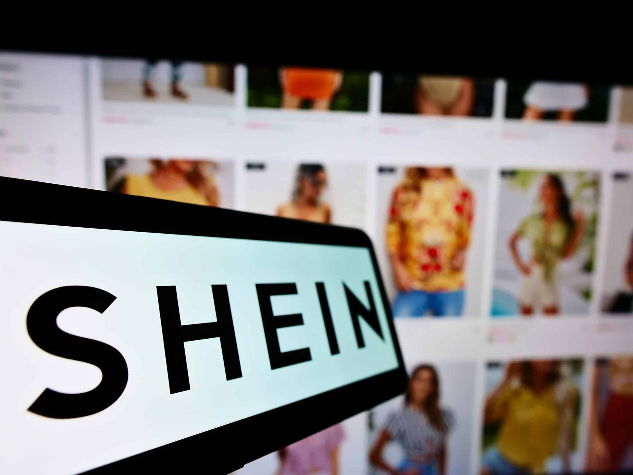 Shein logo on a phone next to a Shein webpage