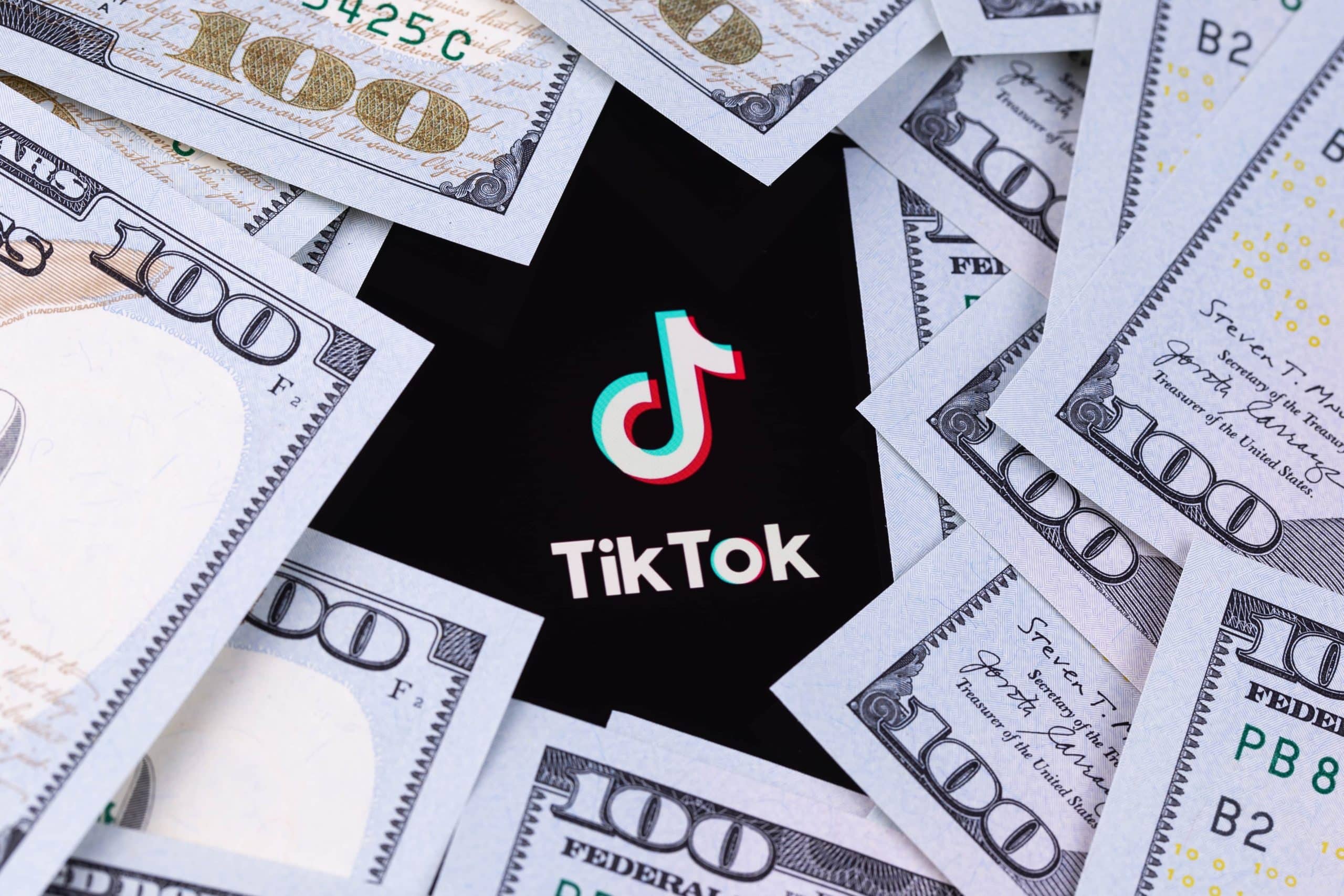 TikTok logo surrounded by 100 dollar bills