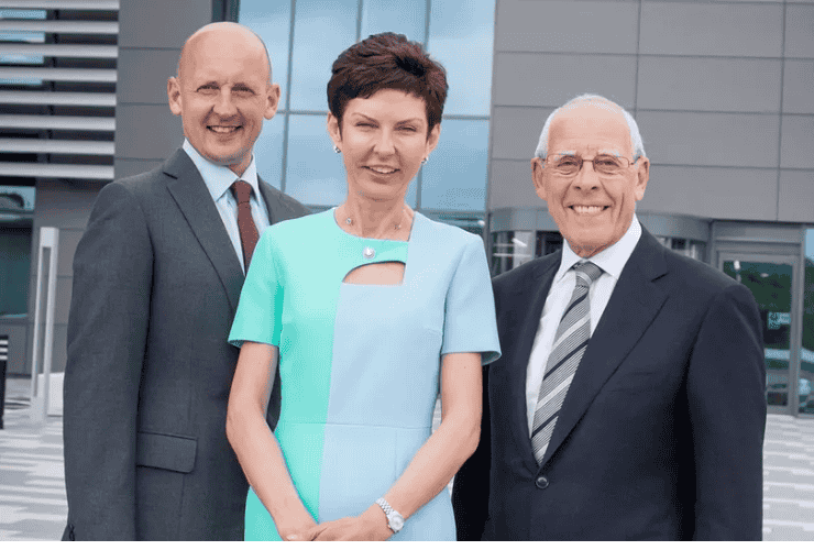 John, Denise, and Peter Coates standing outside Bet365's headquarters in Etruria.